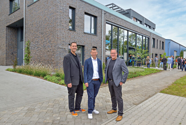Die INperfektion-Gründer Carsten Finke (re.) und Ralf Aldenhoven (li.) freuen sich gemeinsam mit Gronau-Geschäftsführer Benjamin Gronau über den Neubau (© Jan Schmitz)